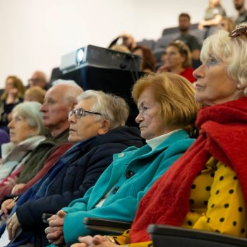 Sideshot of members of the audience taken at a research conference